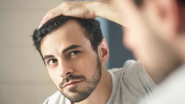 a man checking hair loss in men at side