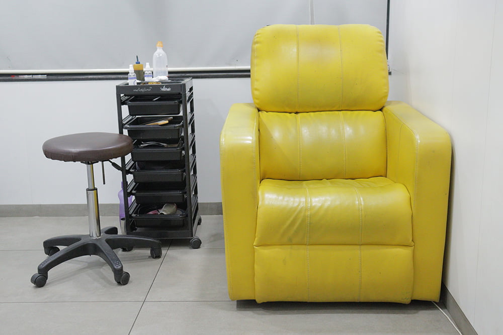 yellow recliner sofa with pre hair transplant treatment tray table at hairfree and hairgrow clinic